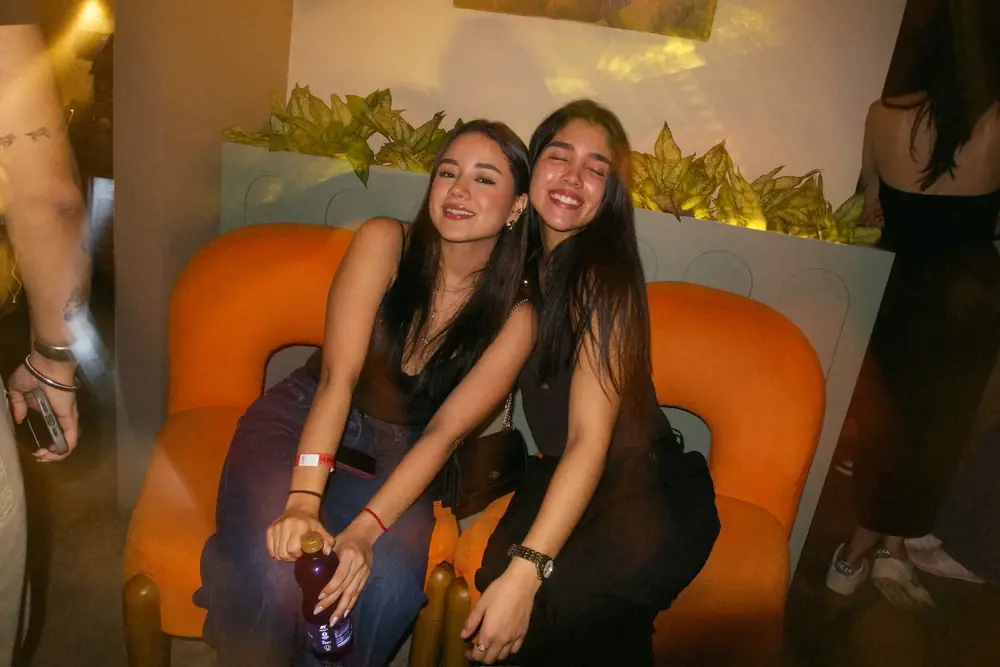 Amigas en un sillón naranja